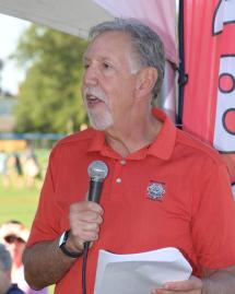 Sam, outdoors, speaking into a microphone