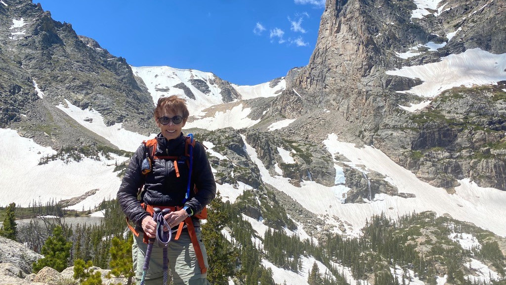 Alice, myeloma survivor, on a hiking trip, standing in front of mountains