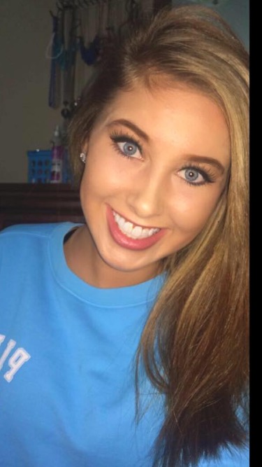 young white woman with long blond hair and blue eyes smiling and wearing a light blue tshirt